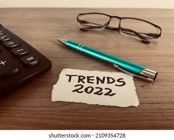 Trends 2022 text with pen, calculator and glasses on office desk, business concept - Shutterstock ID 2109354728