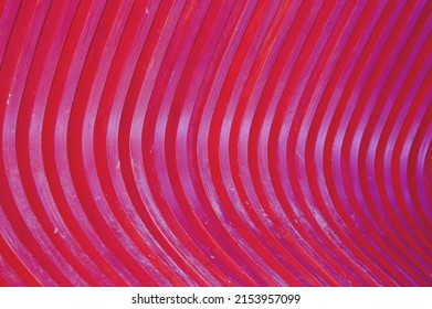 Trendy abstract pattern of wooden slats, wood texture painted in burgundy. Glare of the Sun on a curved surface, a beautiful color gradient.