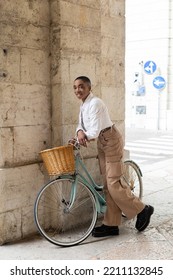 Trendy African American Woman Smiling At Camera Near Bike On City Street In Italy