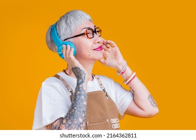 Trendy Asian Senior Old Woman Female Wear Headphone Listening Music Melody While Wear Apron Hand Touch Earphone Casual Relax Lifestyle,easy Listening Music Asia Woman With Tattoo Close Eye Feel Free