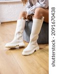 Trendy beige trumpet boots on a female leg, close-up, fashionable. New collection of women