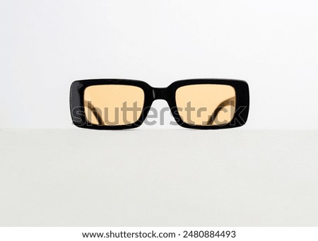 Trendy black rectangular sunglasses with orange lens color isolated on white background