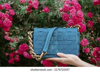 Trendy Blue Leather Wicker Bag, Purse. Summer Fashion Conception. Blooming Rose Garden As Background. Close Up.  Copy, Empty Space For Text