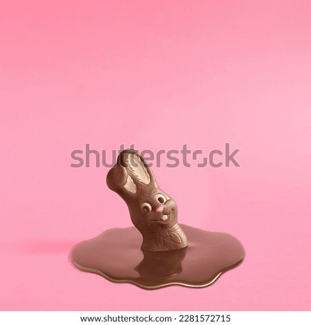 Trendy composition with Easter chocolate bunny rabbit melting on pink pastel background .Creative art, minimal aesthetic look. Contemporary style.Writing space, copy space, minimal easter concept