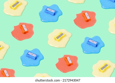 Trendy Composition Pattern With Colorful Pencil Sharpeners Dipped In Liquid On Olive Green Background. Surreal Office Or School Idea.