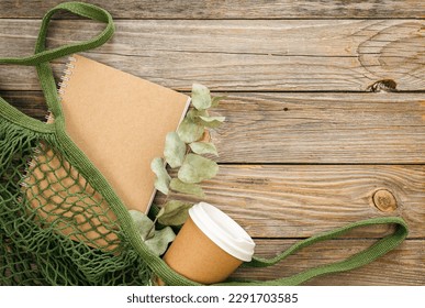 Trendy Cotton Shopping Bag with Disposable Paper Cup and Craft Notepad on Wooden Surface, flat lay. - Powered by Shutterstock