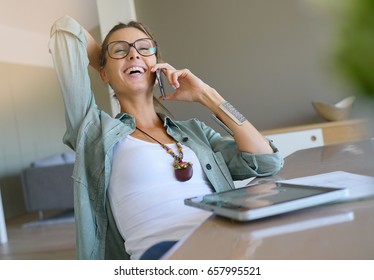 Trendy designer girl talking on phone, home-office - Powered by Shutterstock