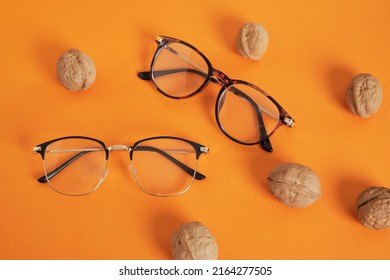 Trendy Eye Glasses On An Orange Background With Walnuts, Glasses For Study, Computer Work And Reading