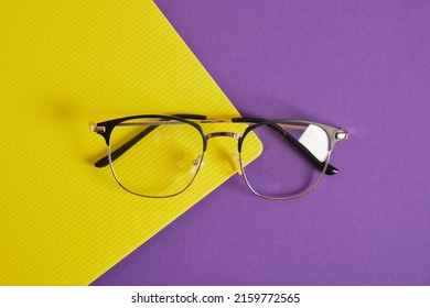 Trendy Eye Glasses On A Purple And Yellow Background Glasses For Study, Computer Work And Reading, Fashionable Eyeglass Frames