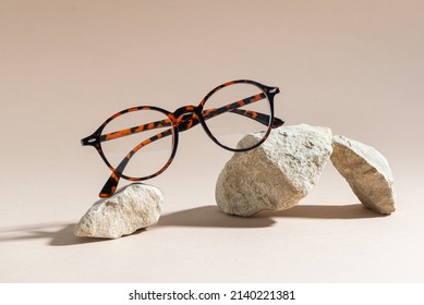 Trendy Eyeglass frame on a beige Background, trendy Still Life Style. Tortoiseshell frame glasses on stones. Optic store advertisement background. Close up. Minimalism. Glasses sale concept. Eyeweare - Powered by Shutterstock