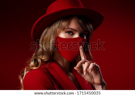 Trendy Fashion accessory during quarantine of  coronavirus pandemic. Woman wearing luxury total red outfit with designer protective face mask. Close up studio portrait. Copy, empty space for text