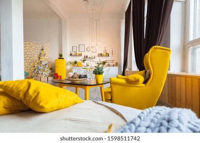 Trendy Fashion Luxury Interior Design In Scandinavian Style Of Kitchen Area In Studio Apartment With Bright Yellow Furniture And Decorated With New Year Tree.