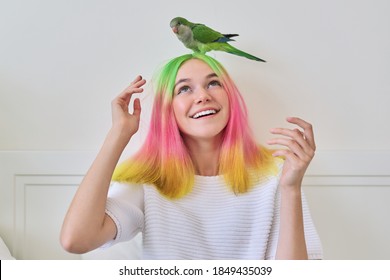 Trendy fashionable and brightly colored hairstyle teenager and green young parrot quaker his head  friendship teen girl   bird  lifestyle teenager   pet