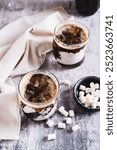 Trendy fluffy coke with marshmallow in  glasses on the table vertical view