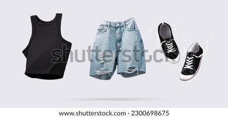 Trendy flying cotton tank top, blue jeans shorts and sneakers isolated on gray background. Clean black crop top. Branding clothes. Mock up for your design. Spring Summer Women's Clothing, horizontal.