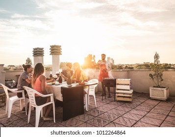 Trendy friends having barbecue party on top of the roof - Happy people doing bbq dinner outdoor - Main focus on woman with yellow t-shirt - Fun, summer, city lifestyle and friendship concept