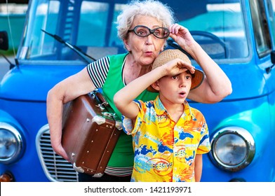 Trendy grandmothers with her grandson in summer wear colorful clothes with a suitcase near the retro car and peer into the distance in surprise. Family summer vacation and travel concept - Powered by Shutterstock