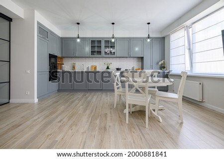 Trendy grey and white modern kitchen with white round dining table in studio apartment [[stock_photo]] © 