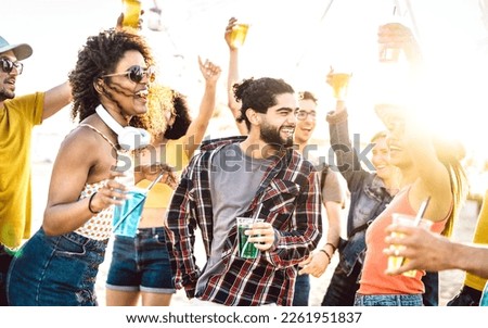 Trendy guys and girls dancing at sunset concert on vacation days - Fancy life style concept with friends having fun together at spring break beach party - Bright vivid filter with sunshine halo