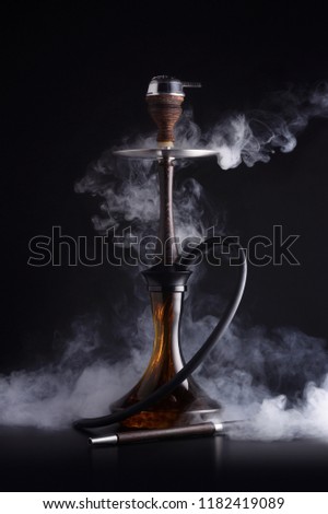 Trendy hookah with cloud of smoke on black background