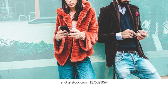 Trendy influencers people using smartphone social media app - Young fashion couple watching story video on mobile cell phone - Technology trends, marketing and new digital job concept - Focus on hands