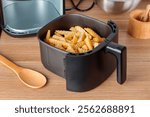 Trendy kitchen gadget air fryer machine cooking deep-fried potato. Lifestyle of new cooking, small countertop convection oven, deep fast frying oil free, more healthful way to cook deep-fried food