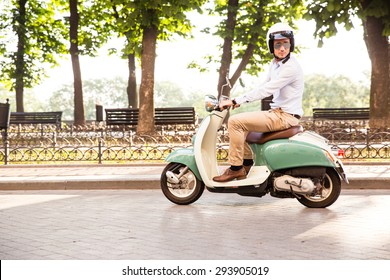 Trendy Man Driving A Scooter In Helmet In Old Town