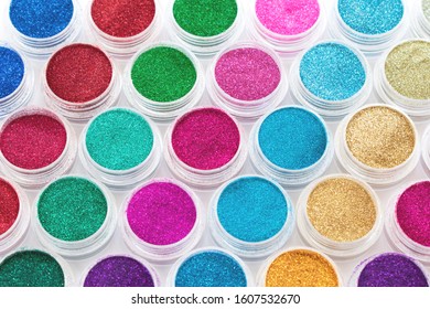 Trendy multicolored glitter in jars  Shimmer  sparkle for makeup  manicure  Shiny powder  Bright pigments  Cosmetic products  Vibrant eye shadow  Blue  pink  green  red  yellow  Selective focus