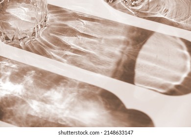 Trendy pattern made with glasses and shadows. glass with sparkling sunlight shadow on the neutral beige background. unlight and blank business. selective soft focus