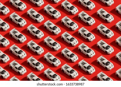 trendy pattern of white toy car model Ferrari on red background