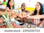 Trendy people toasting fancy cocktails at boat party trip - Young millenial friends having fun on luxury vacation - Travel life style concept with vacationer sharing aperitif drink with tropical fruit