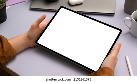 Trendy Purple Office Desk With A Digital Tablet Blank Empty Screen Mockup In Women's Hand. Close-up