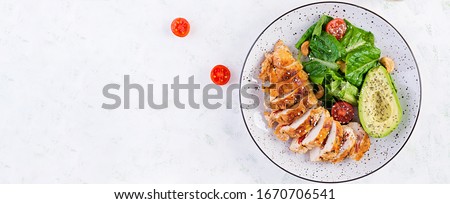 Trendy salad. Chicken grilled fillet with salad fresh tomatoes and avocado. Healthy food, ketogenic diet, diet lunch concept. Keto/Paleo diet menu. Top view, overhead, banner