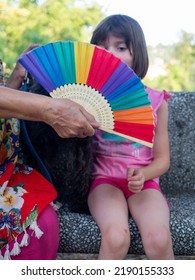 Trendy Senior Lady And Her Little Grand Daughter Enjoying A Park With Their Terrier Dog - Grandmother And Granddaughter Happy Together A Sunny Day