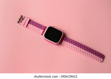 Trendige, intelligente Uhr für Kinder auf rosafarbenem Hintergrund, Draufsicht