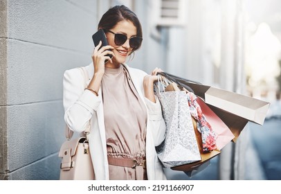 Trendy, Stylish And Fashionable Woman Shopping, Purchasing And Buying Clothes In City, Town And Downtown. Elegant Lady Talking On Phone With Gift Bags, Going On Spending Spree Or Doing Retail