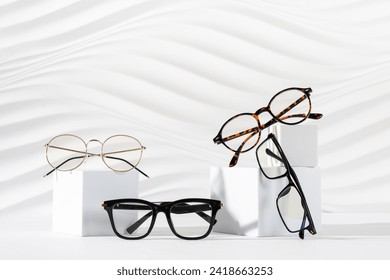 Gafas de sol de diseño y anteojos en podos de fondo blanco. Minimalismo. Copiar espacio. concepto de venta de gafas de sol y anteojos. Cartel de promoción de tiendas ópticas. Moda moderna de Ojo