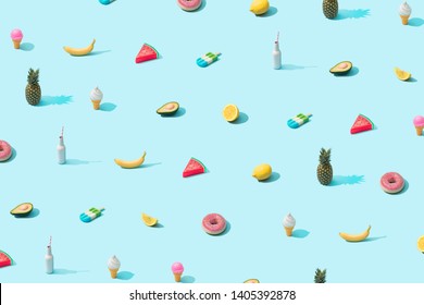 Trendy sunlight Summer pattern made with various summer food on bright light blue background. Minimal summer food concept.