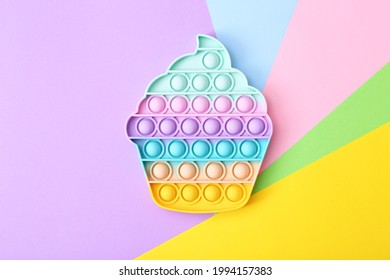 Trendy toy antistress, pop it on a rainbow background, fidget toy, top view