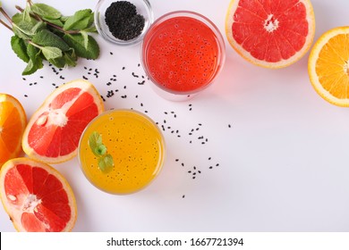 Trendy tropical orange and grapefruit juice with basil seeds or falooda seeds or tukmaria in glass on white background, Closeup, Top view