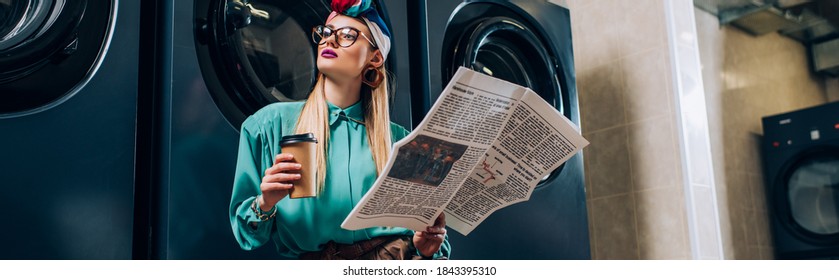 trendy woman in glasses and turban holding paper cup and newspaper in laundromat, banner - Powered by Shutterstock