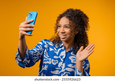 Trendy young african american teen girl making selfie on smartphone on yellow background. Technology, mobile device, social networks concept. High quality - Powered by Shutterstock