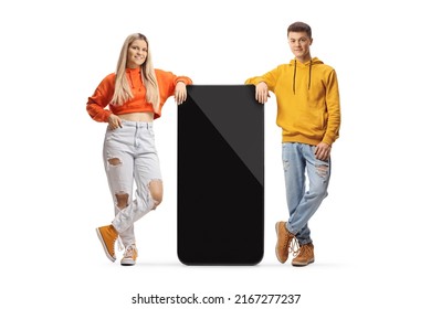 Trendy young guy and girl leaning on a big mobile phone isolated on white background