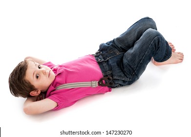 Trendy young toddler boy, lying down on studio white background. Looking to camera with his hands behind his head. Isolated on a white background.