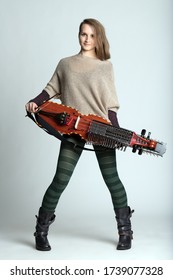 Trendy young woman musician with modern hairstyle wearing tights holding a modern reconstruction of a medieval Swedish nyckelharpa over white