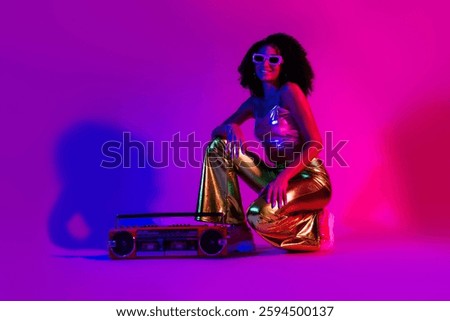Trendy young woman poses with a retro boombox, showcasing vibrant neon lights with purple and pink hues