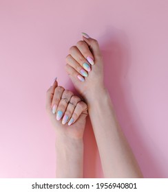 trendy youth manicure in unicorn color  Design and blue   pink stains  Gel polish coating  Hands and varnished nails  Copy space top view  Pstel gentle tones  Fresh summer mood
