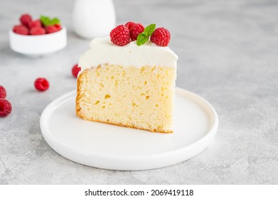 Tres leches cake with whipped cream and fresh raspberries on top of a gray concrete background. Traditional cake from Latin America. Copy space