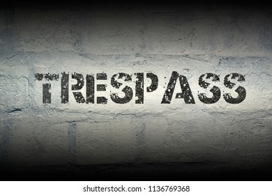 Trespass Stencil Print On The Grunge White Brick Wall