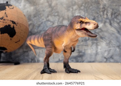T-rex Dinosaur toy. Tyrannosaurus rex with mini globe on wooden table and dark background bare plaster or loft style for the atmosphere of the ancient era. - Powered by Shutterstock - Get 15% off with code: PIKWIZARD15